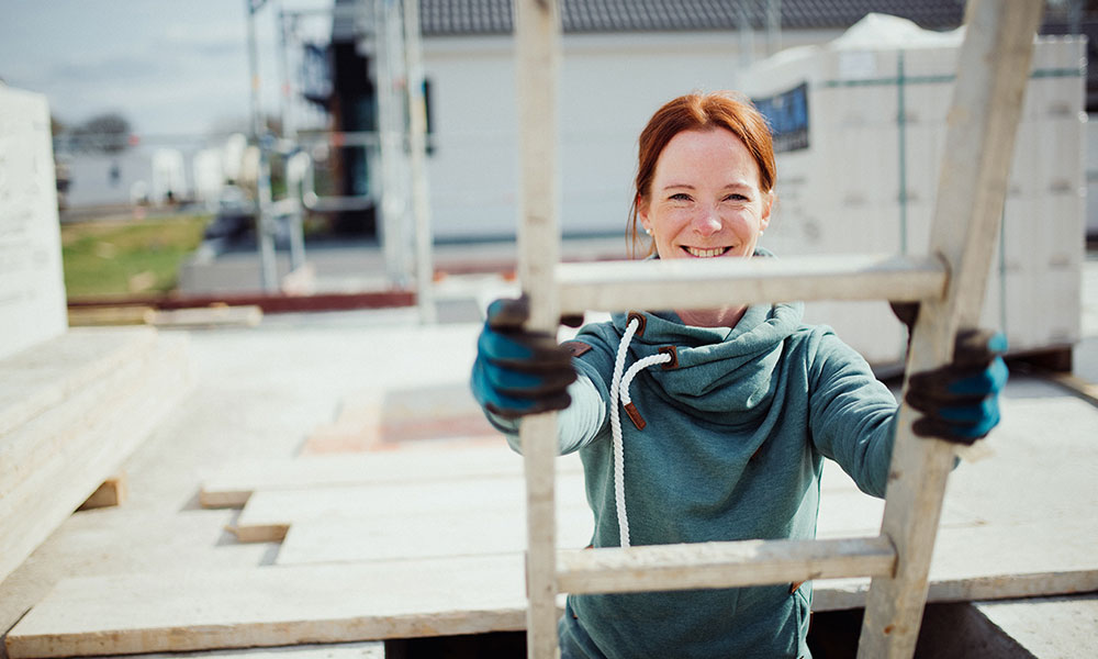Frau die auf einer Leiter steht